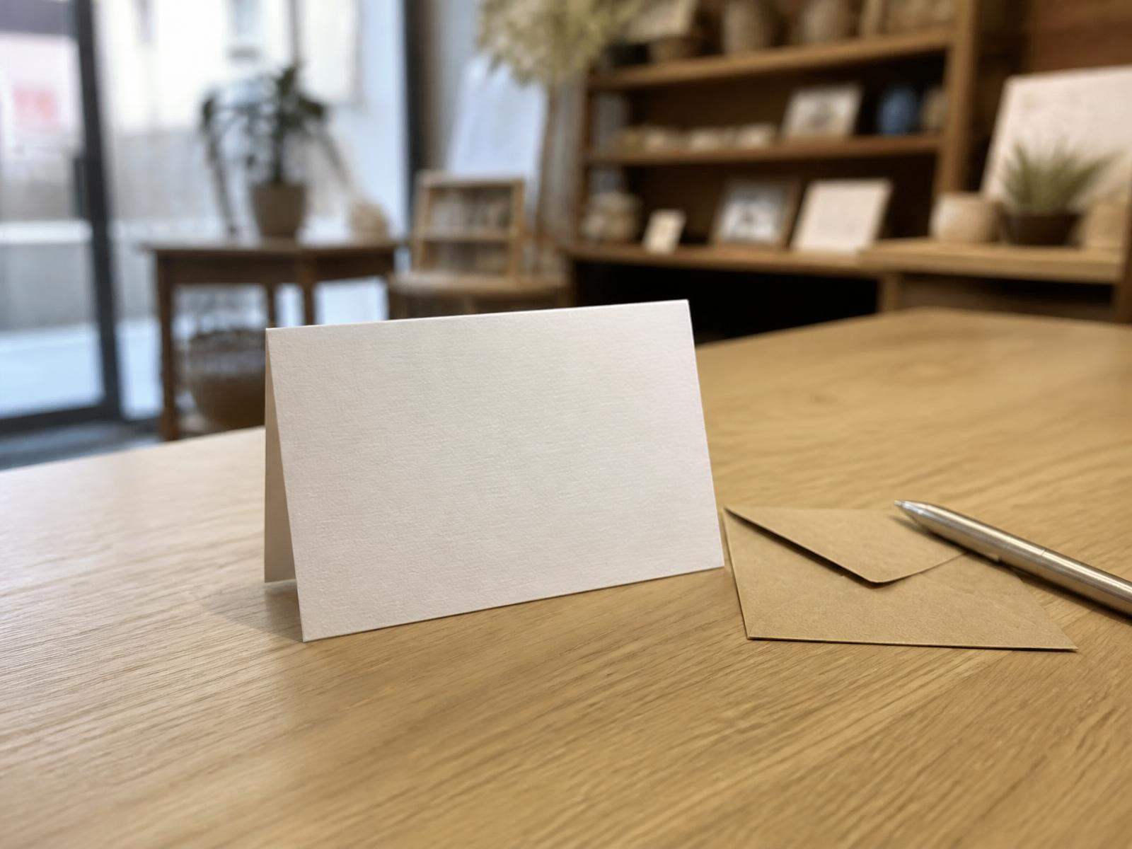 Blanco cadeaukaart met kraft envelop en pen op de balie van onze winkel in Delft